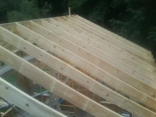 New roof rafters set over an addition before sheathing in Three Bridges