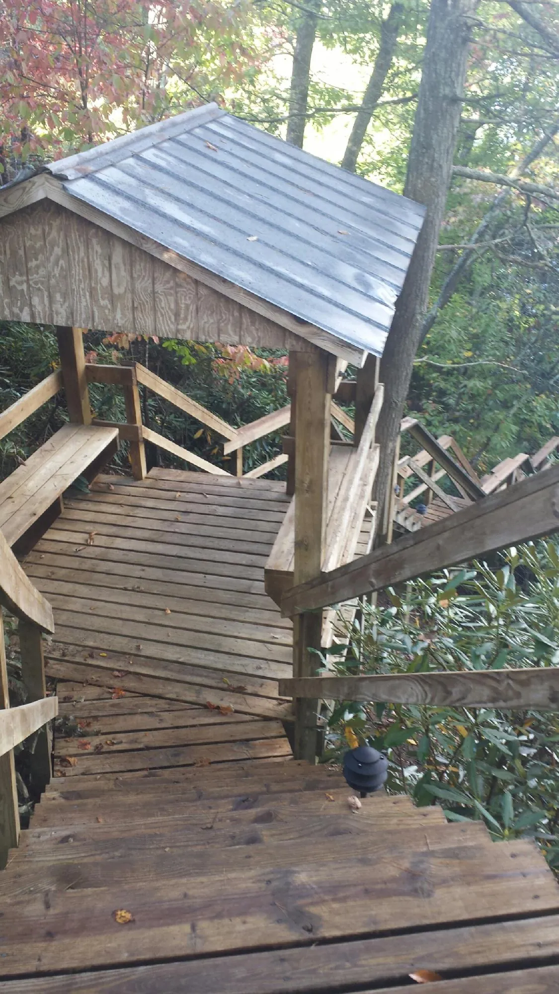 Metal roofed shelter over wooden steps on a wooded walkway — Skylight Repair & Installation work by our crew in Three Bridges