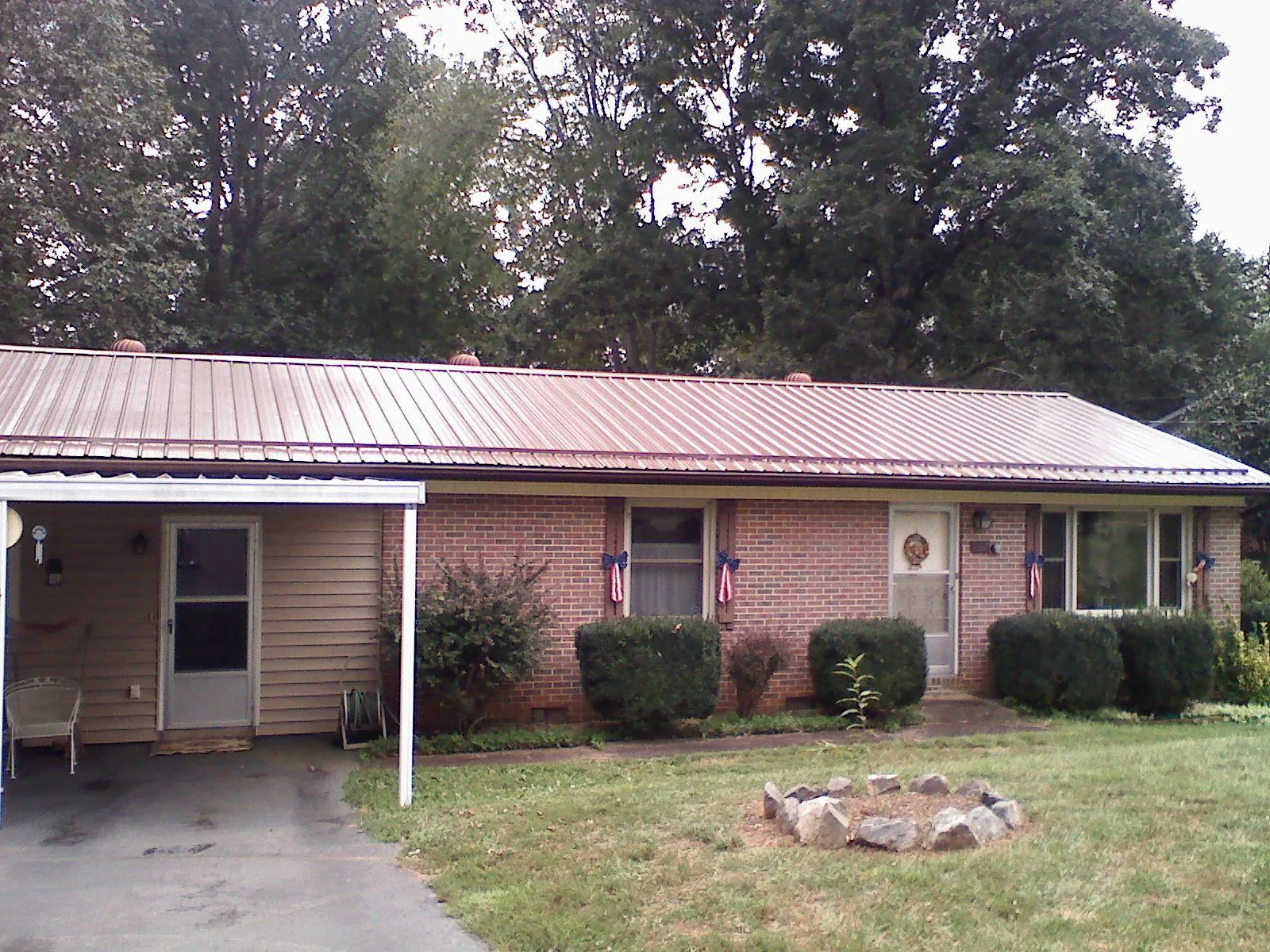 Bronze metal roof and carport on a brick ranch home — Roof Repair work by our crew in Three Bridges
